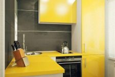 a small minimalist kitchen with bright yellow cabinets and graphite grey walls plus white touches to refresh the space