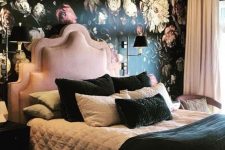 an exquisite bedroom with a floral statement wall, a pink bed and chair, blush curtains, black and white bedding