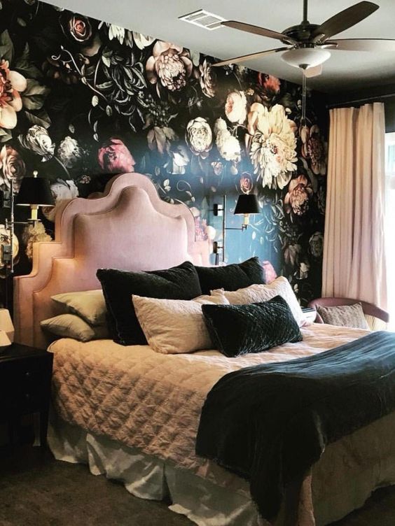 an exquisite bedroom with a floral statement wall, a pink bed and chair, blush curtains, black and white bedding