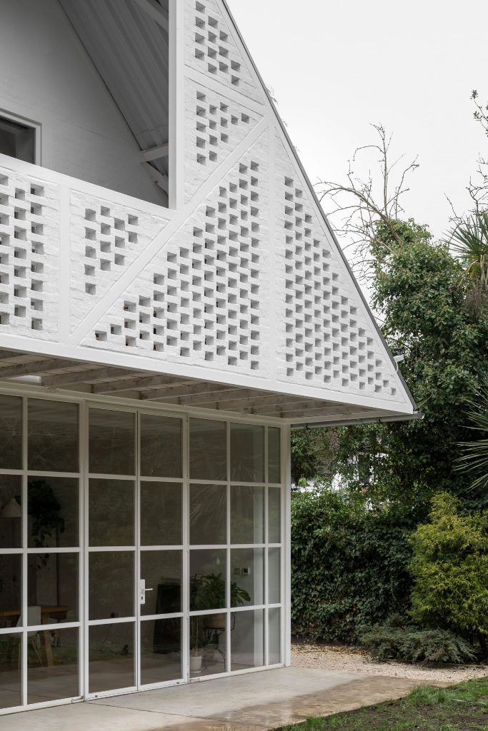 The facade is done with white bricks that imitate Tudor facades of the neighbors