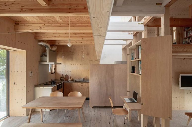 A large storage unit with a hidden desk divides the meal spaces and the living room, and skylights make them feel fresh