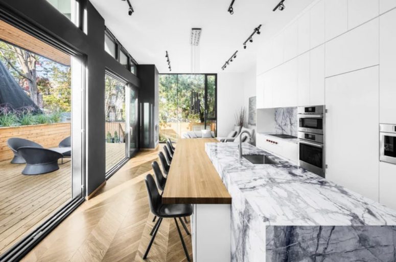 There's a large kitchen-living-dining layout in the extension, it's white and with a white marble kitchen island