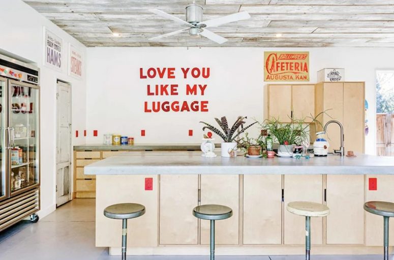 The kitchen is a cozy space with retro touches, plywood furniture and even a shop-like fridge