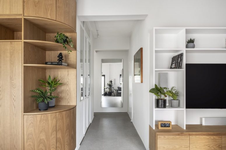 A bright corridor separates two different sections of the apartment, the private and the public areas