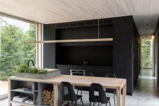 04 The kitchen is done in black, there’s a wood and stone kitchen island that doubles as a dining table