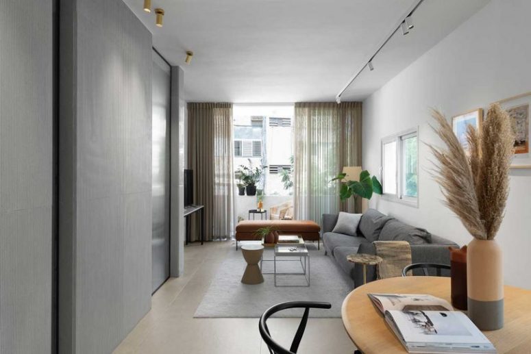 The living room is very laconic, and elegant and timeless furniture creates a mood, potted plants add coziness