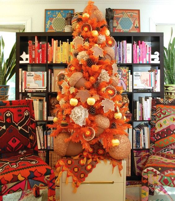 a beautiful fall tree in orange, with pinecones, citrus, oversized acorns and ornaments is very unusual