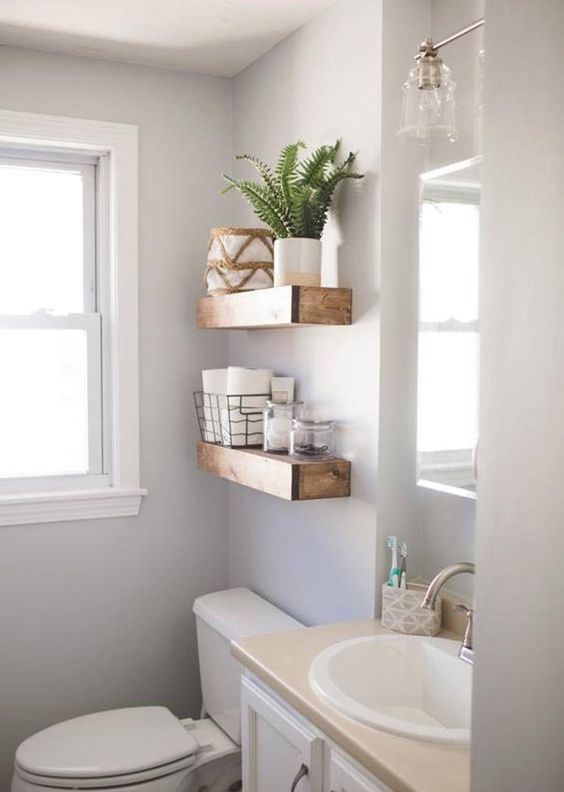 thick wooden open shelves over the toilet give a strong rustic feel to the space