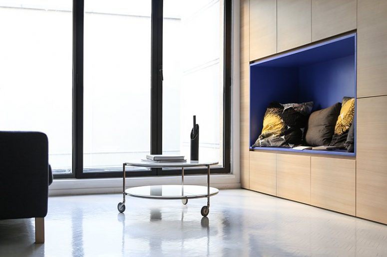 A blue alcove offers a comfortable, sheltered enclosure for reading near the window
