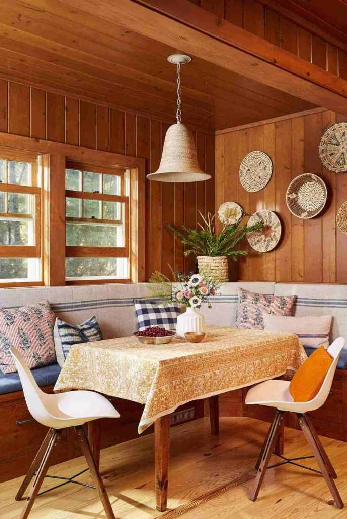 The dining zone features a built-in seat with lots of pillows, chairs and a table