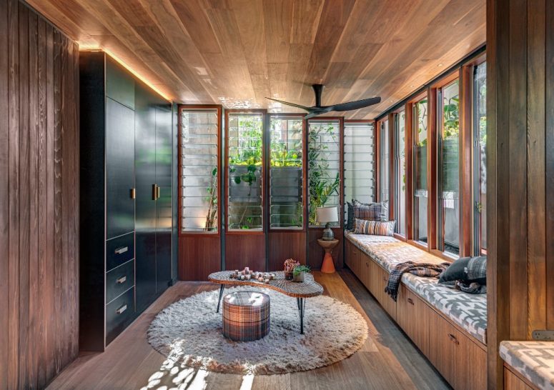 This is a kid's room that has seating that doubles as storage and features much natural light