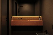 07 The bathroom is done in black, with a red pigment cement vanity and sink