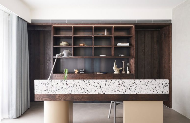 The home office is also here, with a large dark stained storage unit, a dark desk with terrazzo