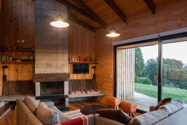 The living room is also covered with wood, there are wooden beams and a hearth plus bright boho folk textiles
