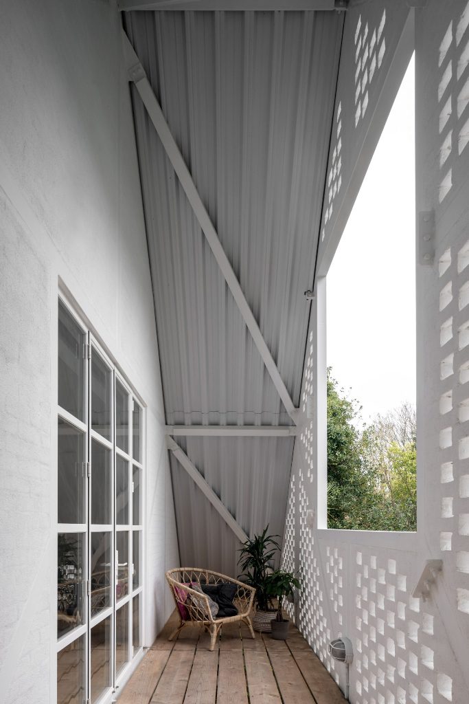 There's a small balcony under the cover, with a rattan chair and some plants