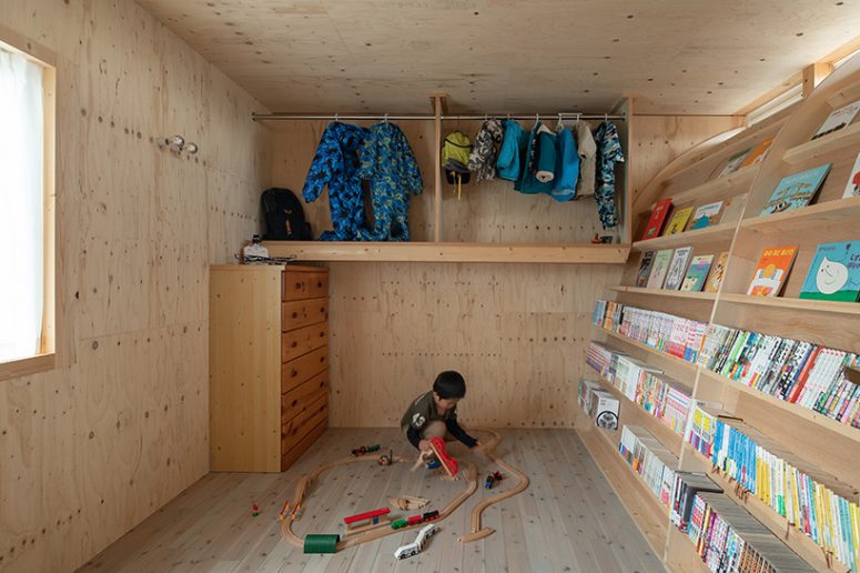 This is a creative kid's room with toys, a siddeboard, some holders and hangers under the ceiling