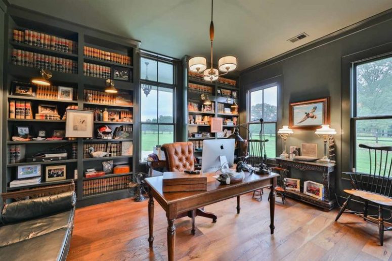 masculine home office design with lots of windows The home office is dark and moody, with built-in shelves, vintage furniture and pendant and table lamps in vintage style