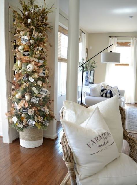 a cool fall tree with lights, burlap ribbons, oversized acorns, family pics and branches plus pumpkins