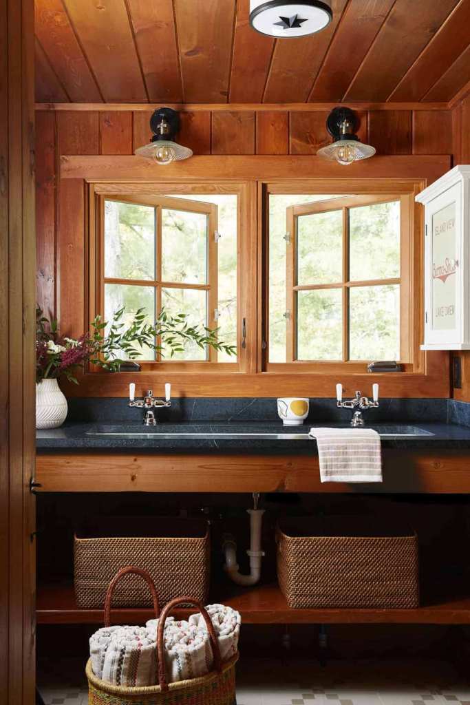 The master bathroom is done with stone countertops, baskets and flowers