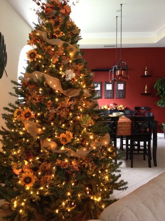 a cozy Thanksgiving tree decorated with lights, pinecones, faux sunflowers and faux white blooms plus burlap ribbons