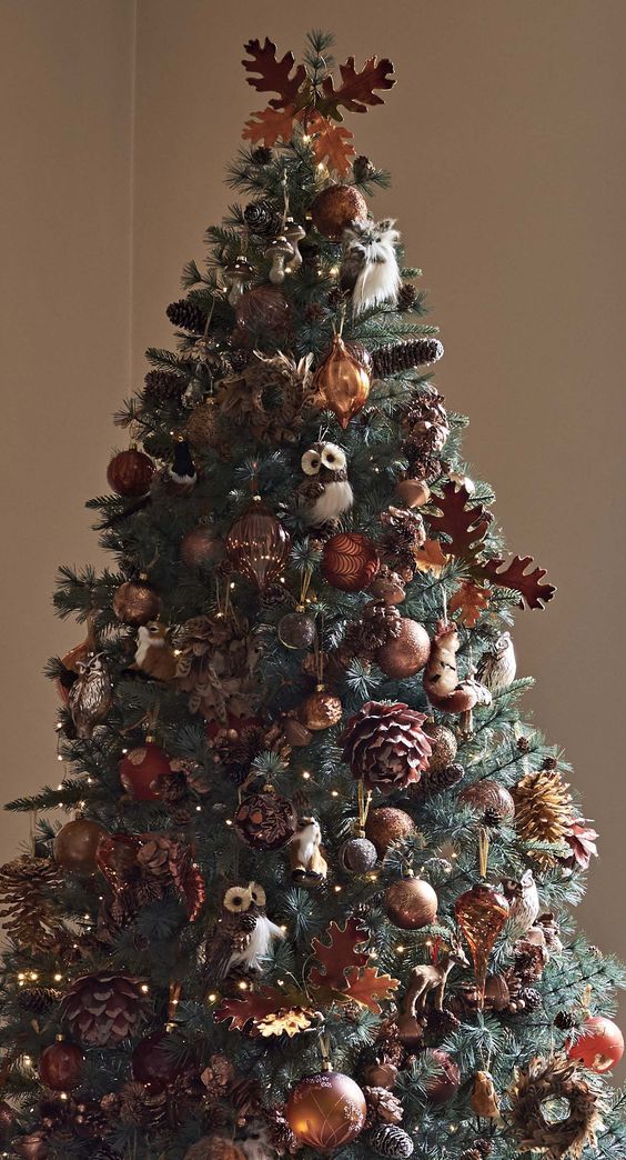 a fabulous fall tree decorated with gold and brown ornaments, plywood leaves, pinecones, lights and faux owls