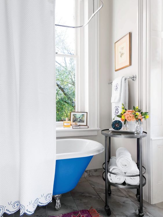 a round black metal and glass cart is a stylish idea to display some decor and store towels