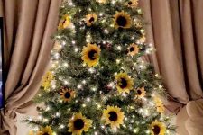 17 a simple and bright fall tree with lights, pinecones, faux sunflowers and an oversized brown bow on top