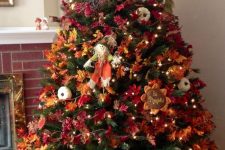 21 a bold vintage-inspired Thanksgiving tree with lights, bright leaves, pumpkins, faux blooms and a scarecrow
