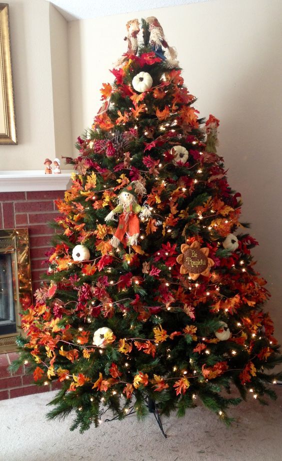 a bold vintage inspired Thanksgiving tree with lights, bright leaves, pumpkins, faux blooms and a scarecrow