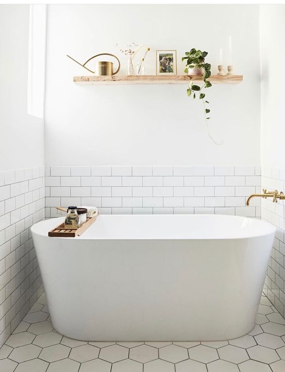 a contemporary neutral bathroom with an open floating shelf over the tub to store and display some decor