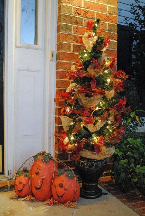 a simple fall or Thanksgiving tree decorated with faux leaves, burlap ribbons and lights is a stylish outdoor decoration