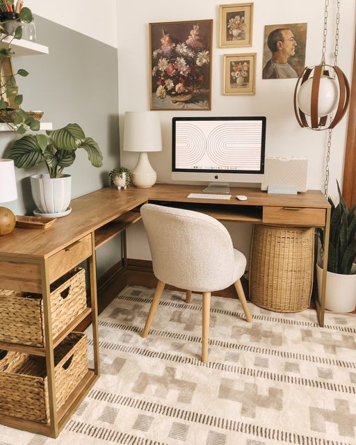 a cozy working space with a stained corner desk, baskets, a neutral chair, a gallery wall, potted plants and a pendant lamp