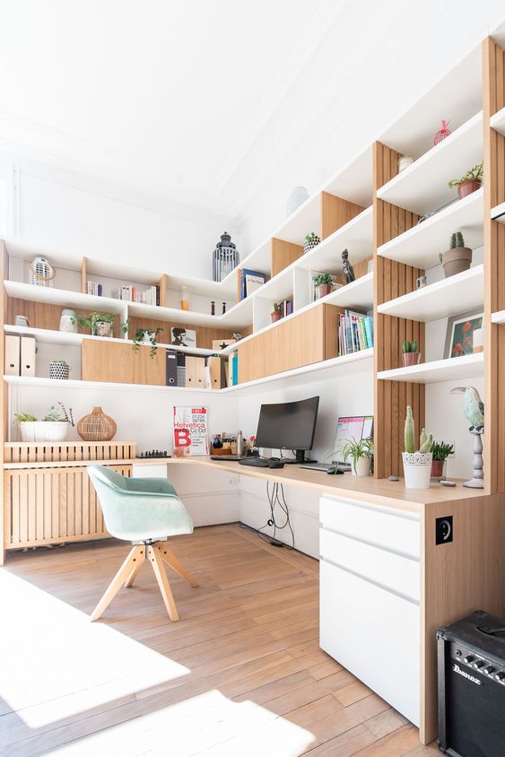 a stylish Scandinavian home office with customized storage furniture and a built-in desk, a green chair, decor and books is amazing