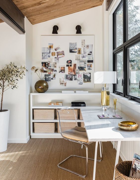 a stylish and refined home office with a corner desk and open storage units, a jute rug and an acrylic chair is very chic