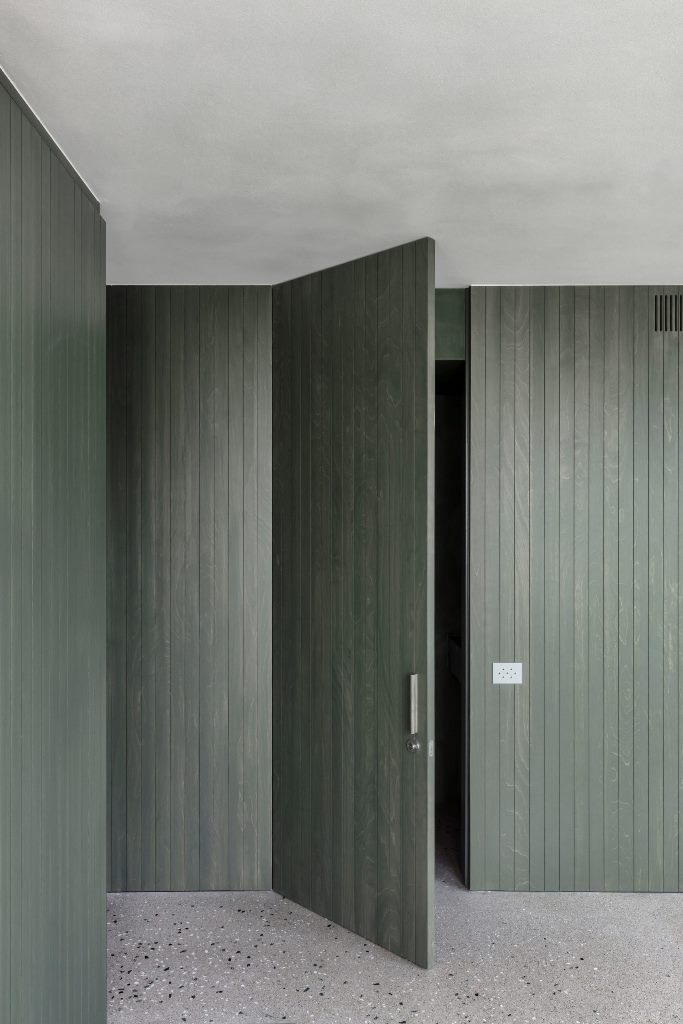 The same green stain has been applied across the apartment's wood-panelled walls