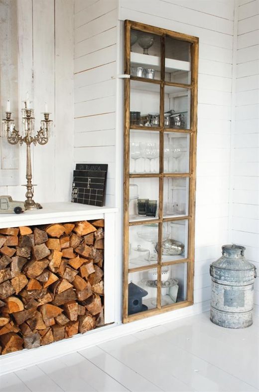 a built in storage unit with a glass door made of old window frames is a stylish idea for a rustic space