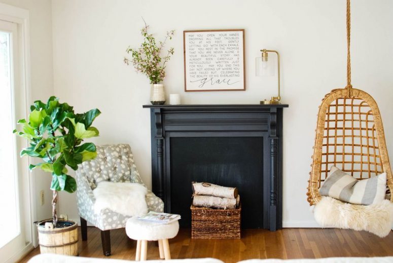 a black faux fireplace with a refined mantel, a basket with wooden logs is a stylish rustic idea to go for
