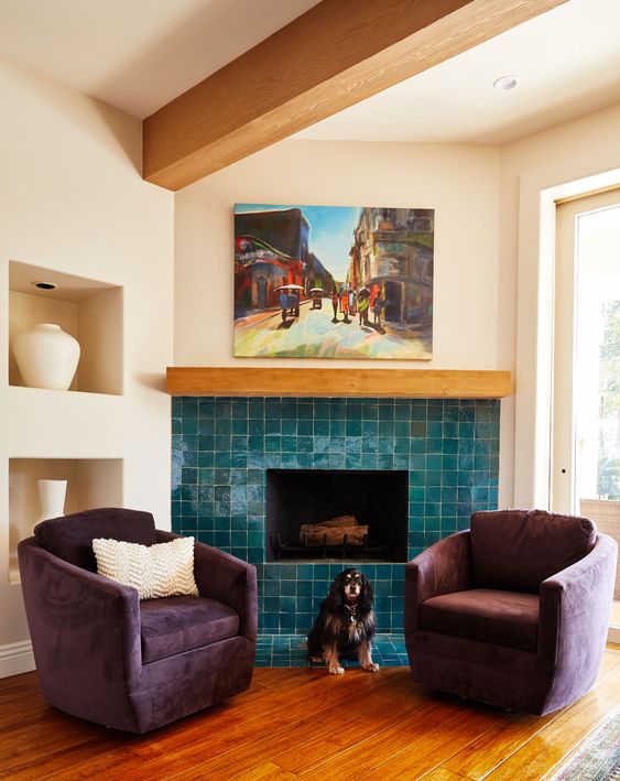 a chic and cozy nook with a fireplace clad with glossy blue tiles and purple chairs is a bold space decorated with impeccable taste