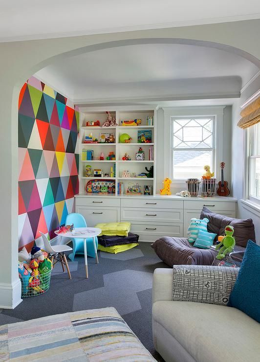 an ultimate playroom with a colorful statement wall, a neutral storage unit, some comfy chairs is very cool