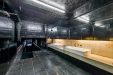 06 The bathroom is all black, with a stone vanity and tiles and other surfaces in black