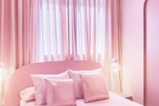 06 The bedroom is done in pink, with a pink bed on a tiled platform, pink and shiny pillows, a pink curtain and lights