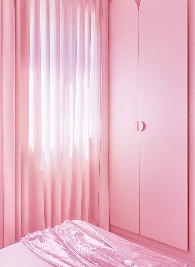 The storage is delicately hidden in the walls and the wardrobe features sleek and simple pink doors