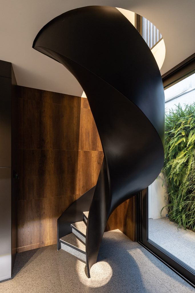 A black spiral staircase features in the kitchen