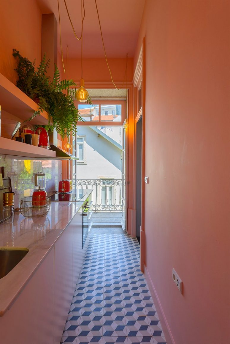 Red appliances and other touches add color to the kitchen, and a balcony entrance fills it with natural light