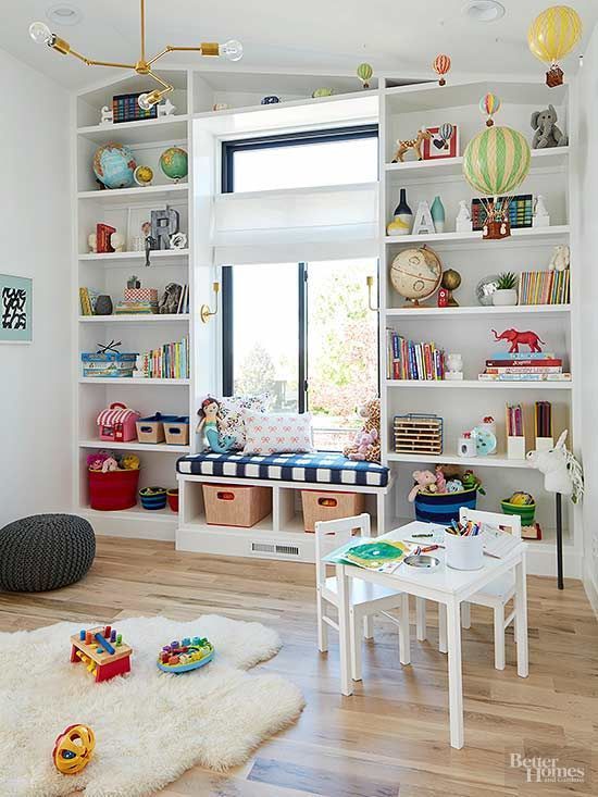 a vivacious playroom with open storage spaces, a windowsill bench, white furniture and colorful toys and books