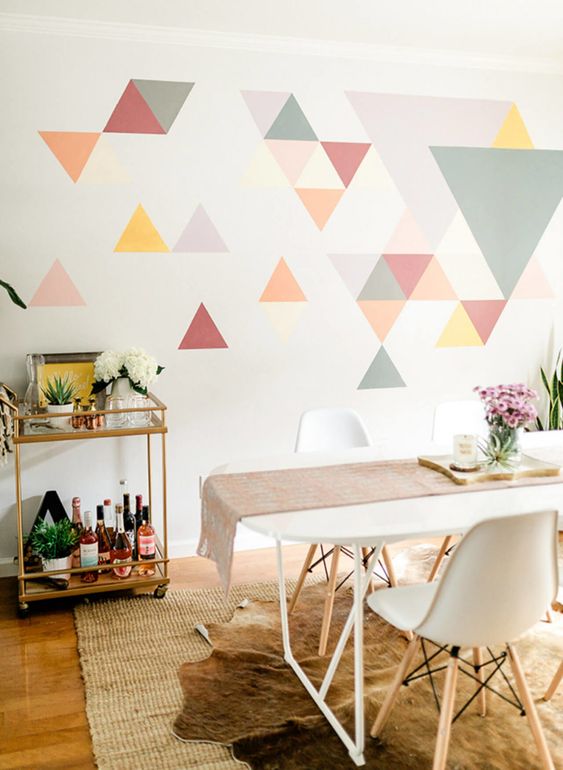 a colorful geometric accent wall done with bright triangles is a creative idea for a modern dining room