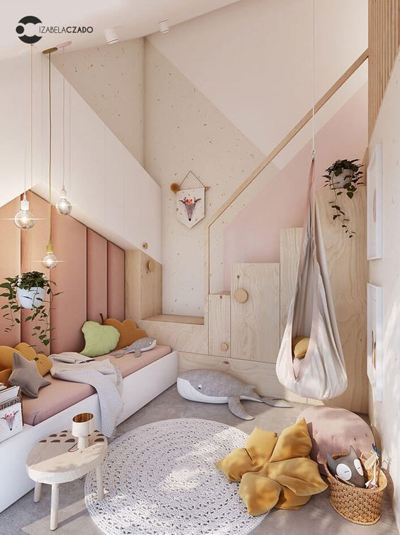 a contemporary pastel bedroom with an upholstered wall, creative storage units, layered rugs and pretty throws and toys
