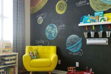 11 a colorful modern kids’ playroom with a chalkboard wall, bold furniture and a rug, colorful crayons and books