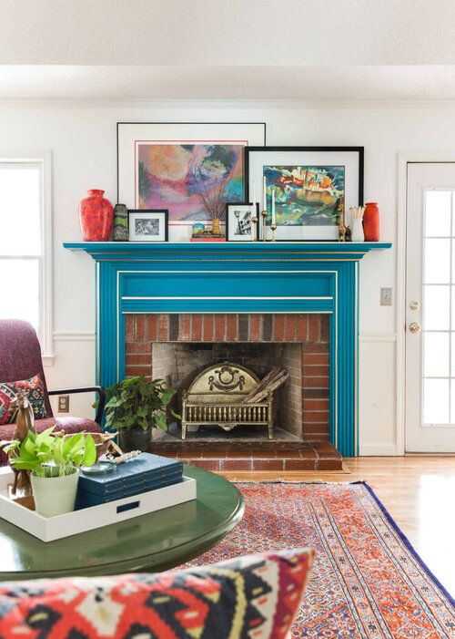 a bright mid-century modern living room with a bold blue mantel with white framing over a brick fireplace for ultimate elegance