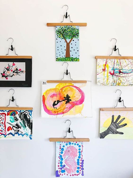 a bold gallery wall with lots of kids' artworks hanging is a creative and chic idea to try